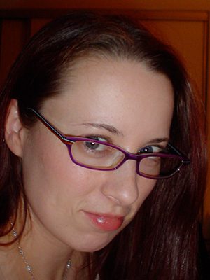 A woman with glasses looking at the camera.