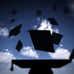 A group of graduation caps flying in the air.