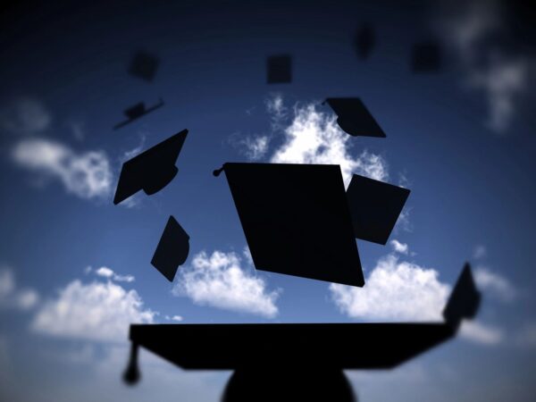 A group of graduation caps flying in the air.