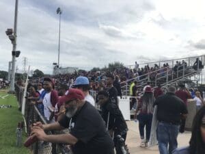 A crowd of people standing on top of a field.