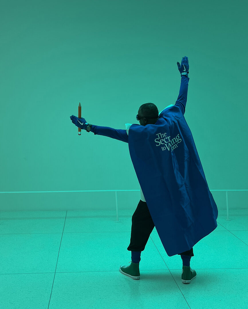 A person in blue cape holding a pair of scissors.