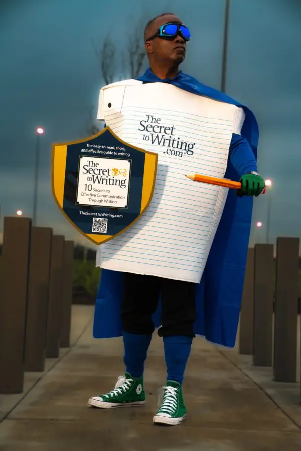 A man in a costume holding a paper and a pencil.